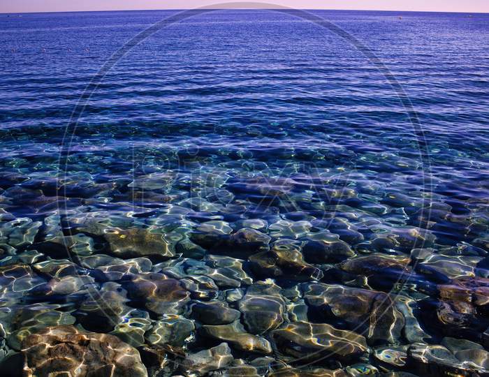 Crete Island, Greece: Clean See Through Transparent Water Of Mediterranean Sea With Gentle Waves.