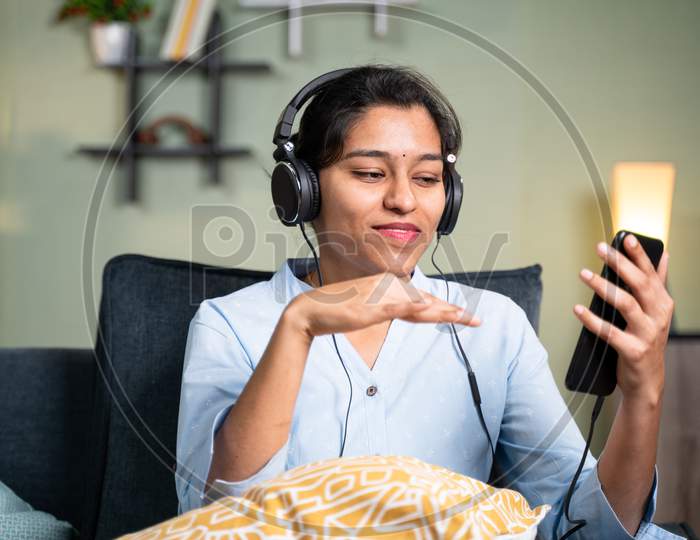Young Girl Enjoying While Listening Music By Making Hand Gestures To Beats Of Song - Concept Of Music Lover, Lazy Weekend Relaxation And Modern Day Lifestyle