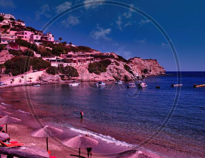 Crete Island, Greece: Wide Angle Cityscape Showing Blue Mediterranean Beach Near Heraklion City With Tourist During Summer
