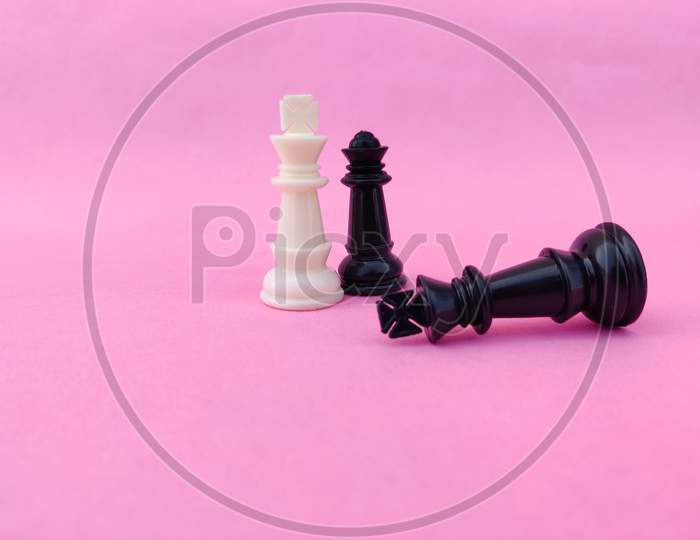 Black Chess King Surrendered To White Chess King And Black Chess Queen. Pink Background
