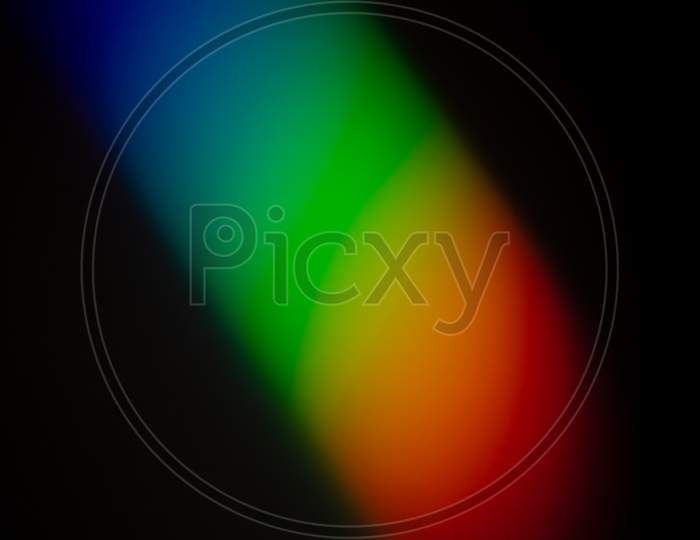 Clear And Vibrant Rainbow Color Gradient Reflect On A Dark Wall Photograph.