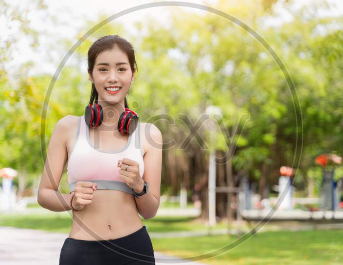 Asian Women Wear Costumes For Exercise And Jacket Running In The Park,Asian Women Are Practicing To Run A Marathon Or Cardio To Lose Weight Sport And Healthy Concept With Park Background.