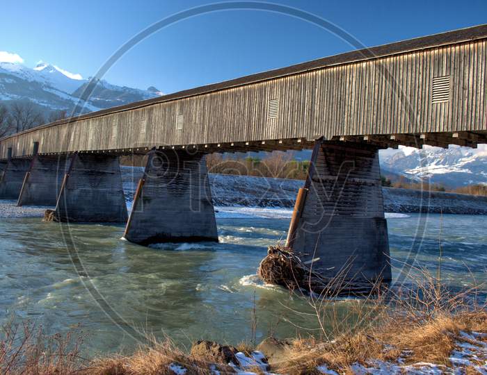 Wooden Old Bridge Across The Rhine River In Vaduz In Liechtenstein 7.1.2021