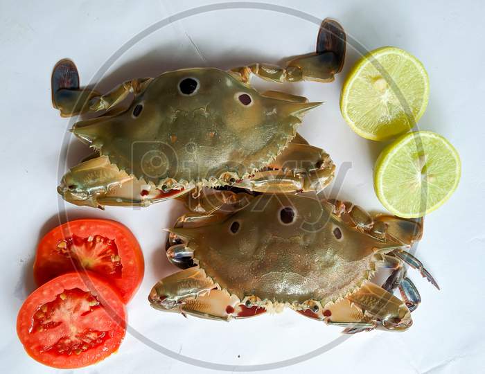 Selective Focus Of Fresh Three Spotted Swimming Crab Decorated With Lemon Slice And Tomato Slice . Isolated On A White Background.