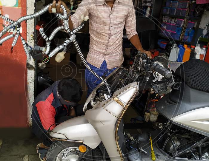 Auto Garage Work On Two Wheeler Repairing Wire And Seat Cover