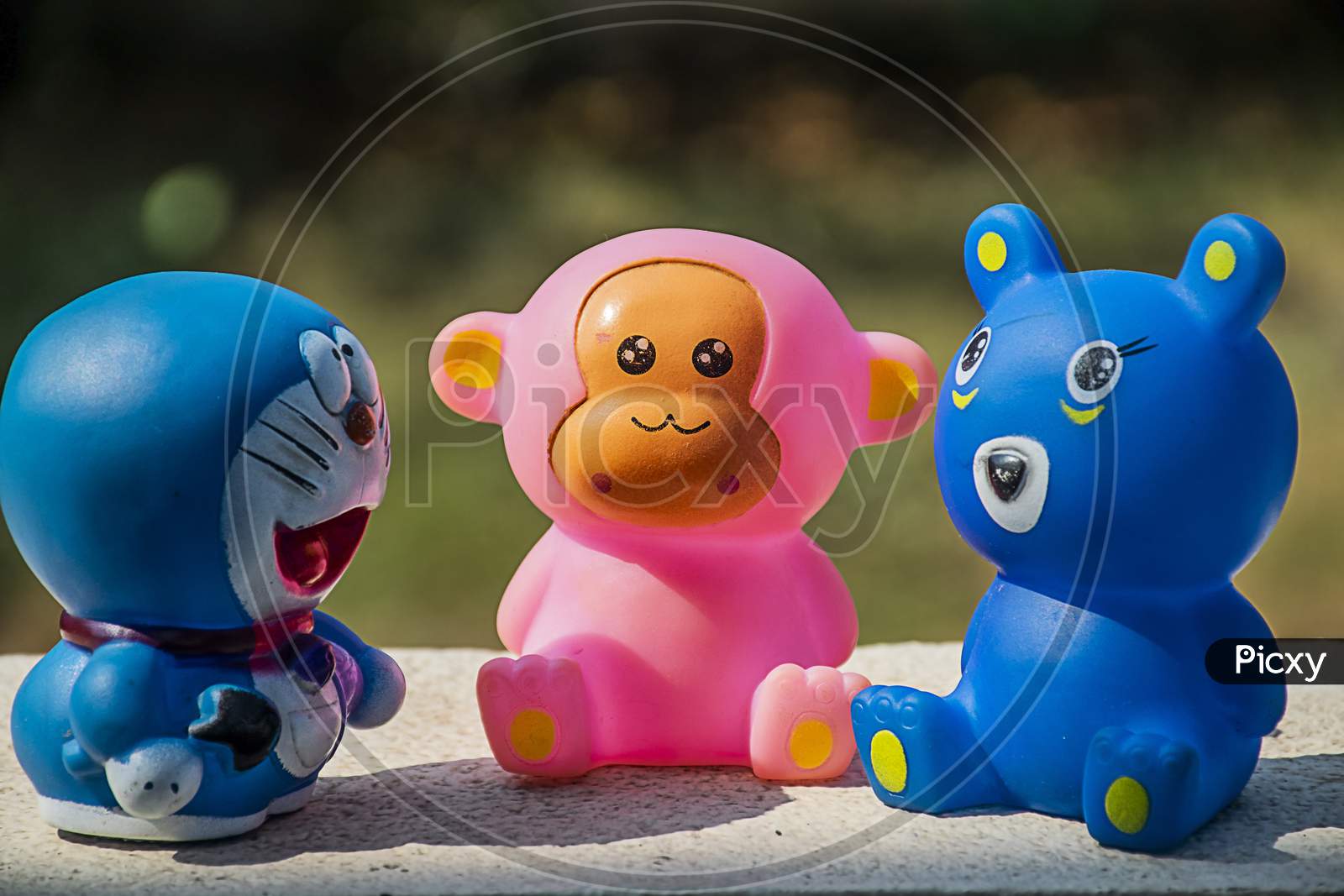 Group Of Three Cute Small Toys On The Floor, Blurred Background
