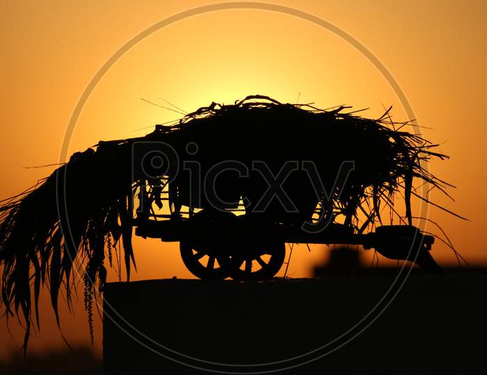 silhouette of a bullock cart in the sunset