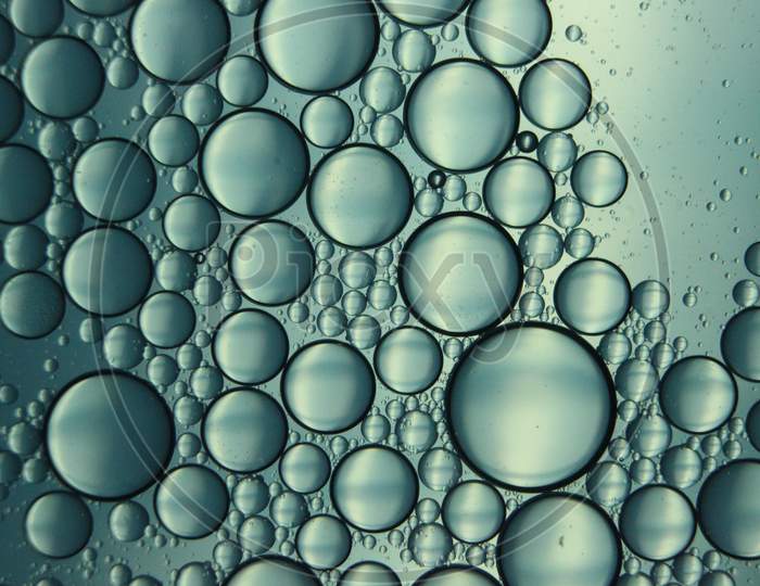 Abstract Macro Background Of Oil Circles Floating Over Water Surface .
