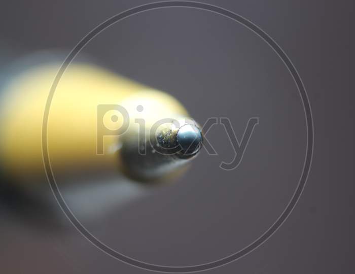 Macro Photo Of Ballpoint Pen Tip With Dark Grey Background.