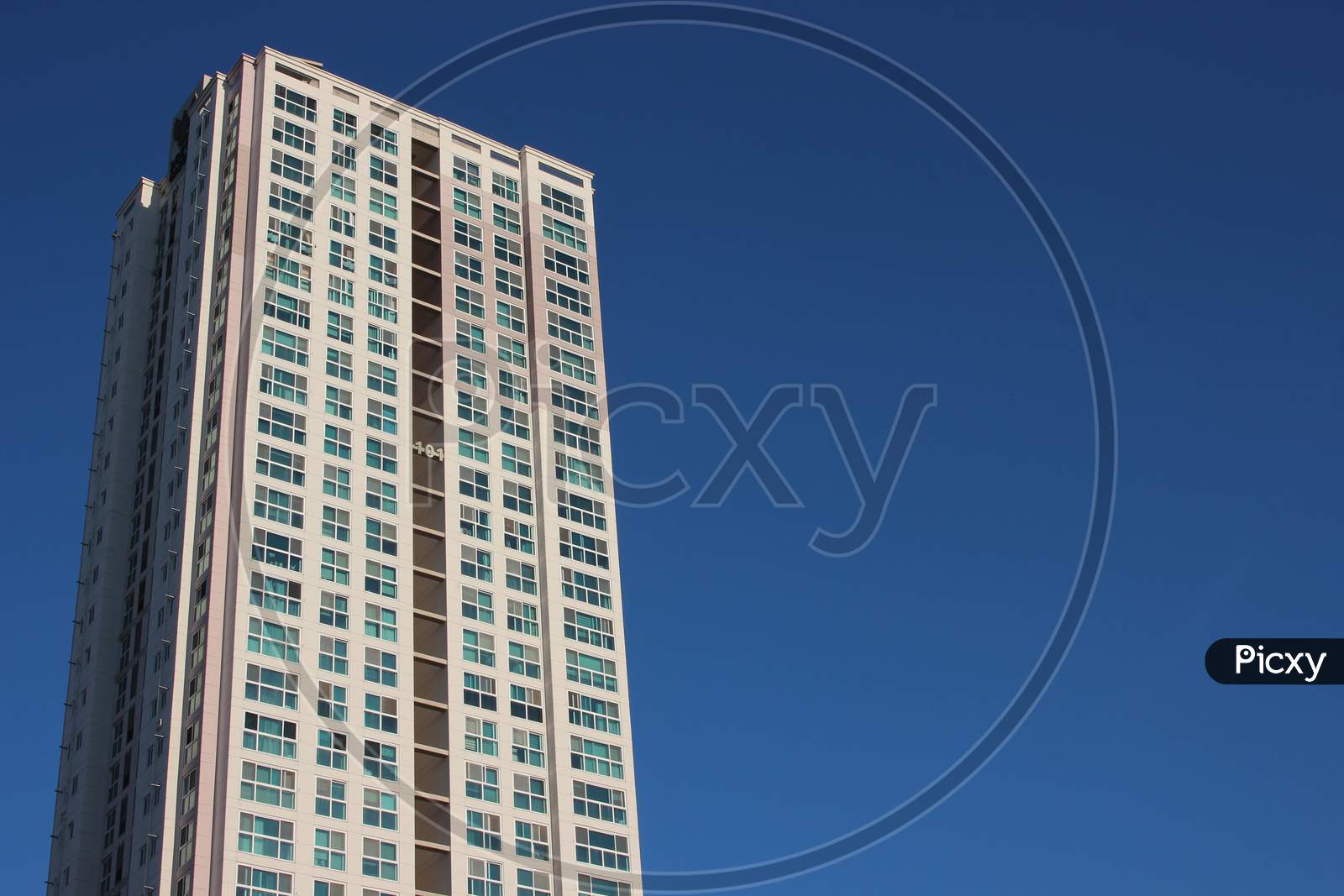 The Wide-Angle View Of A Skyscraper Commercial Building With Blue Sky On Sunny Day.
