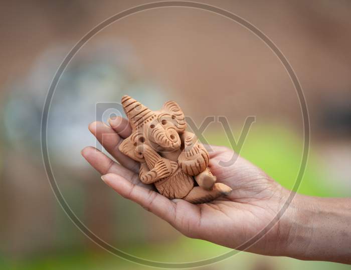 lord Ganesh clay idol held in hand