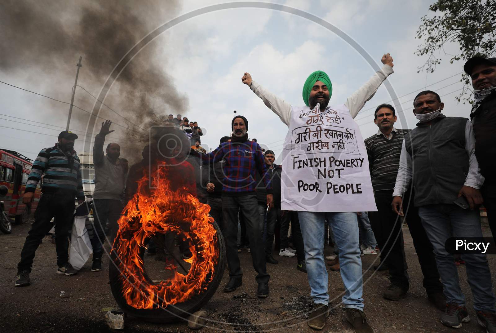 Bus drivers burn tyre during their day-long strike from Lakhanpur to Kashmir, organized by All J&K Transport Welfare Association, in support of their demands like waiving off token tax, passenger tax and renewal fee penalties due to COVID-19, at a bus stand in Jammu,6 Jan,2021.
