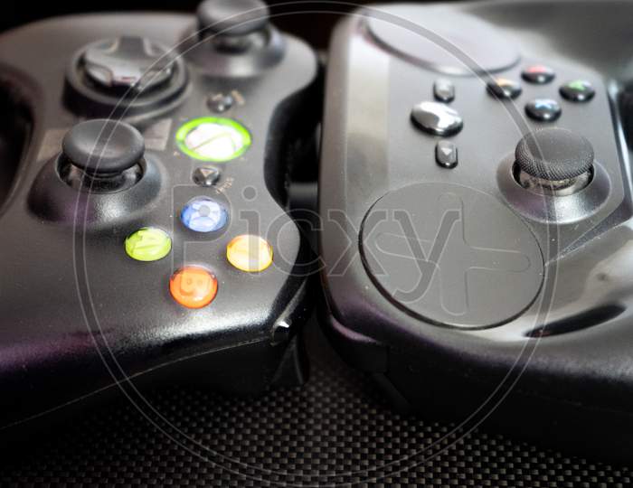 Xbox Vs The Steam Controller On A Carbon Fiber Background Showing Technology Of Inputs For Computer Gaming