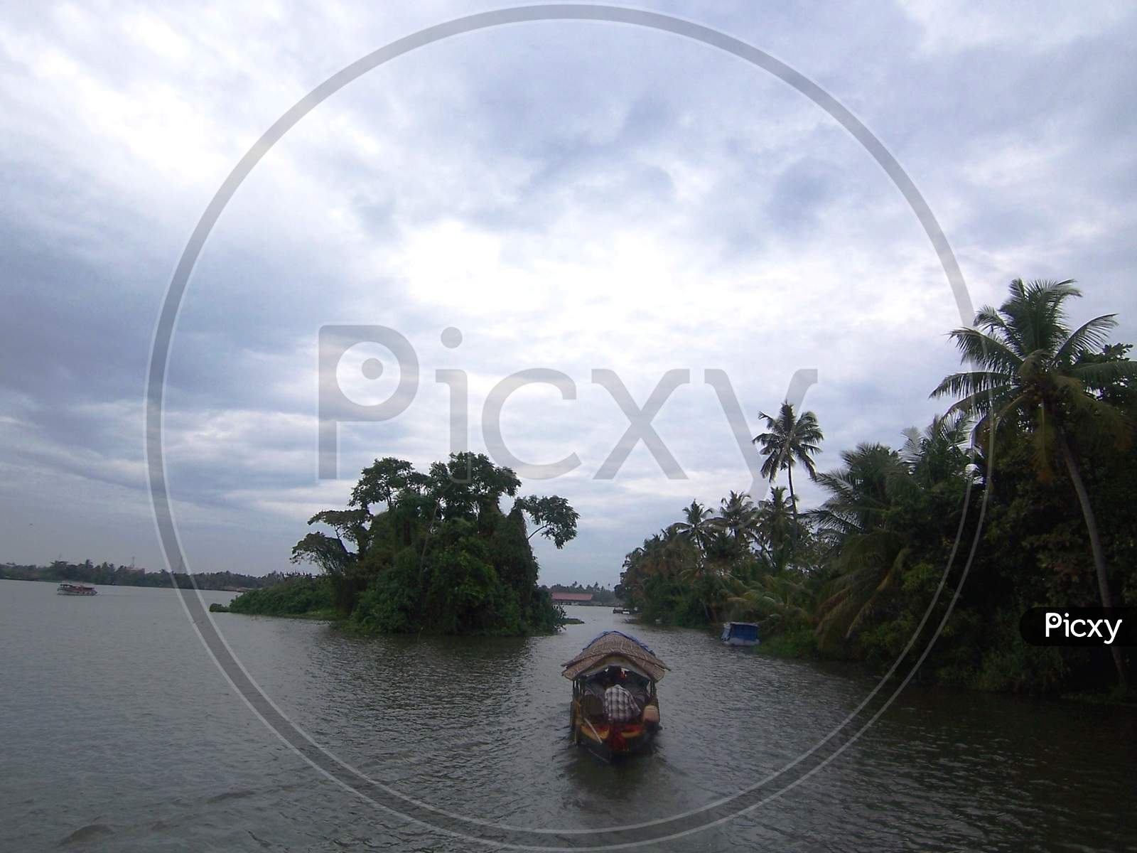 Boat, coconut trees, island and clouds at alleppey, kerala backwaters