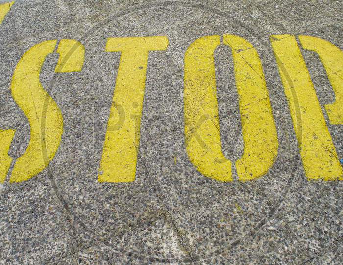 Stop Sign Painted On Asphalt.