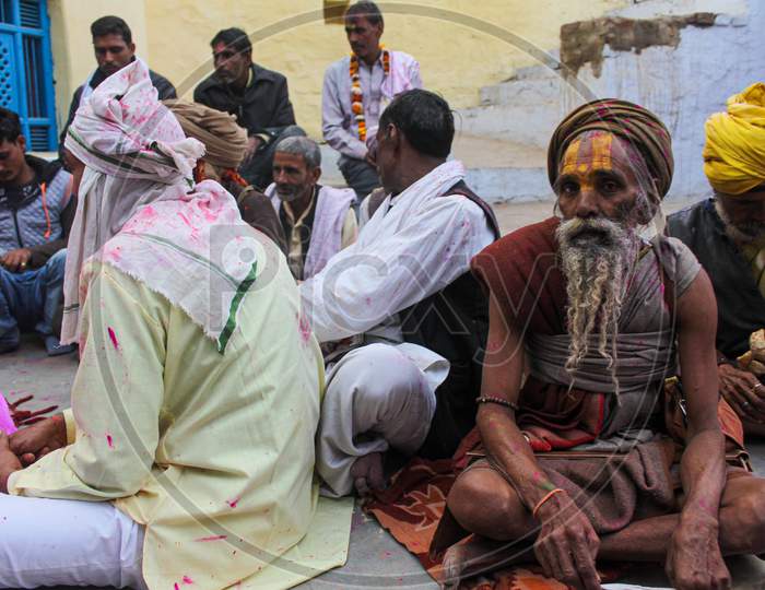 Mathura, Uttar Pradesh/ India- January 6 2020: Indian Sadhu Baba (Monk) Participating In Holi Festival With Colorful Faces At Mathura And Old Men Gathering Together.