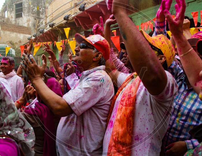 Mathura, Uttar Pradesh/ India- January 6 2020: A Crowd Of People Raised Their Hands Up And Enjoying Music On The Street Of Mathura Celebrating Holi Festival With Color Powder.