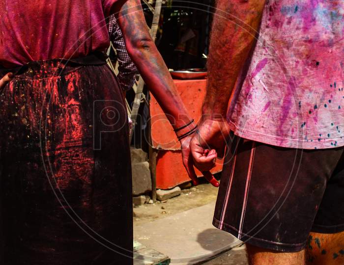 Mathura, Uttar Pradesh/ India- January 6 2020: Young Man Woman With Stains Of Color On Their Clothes And Holding Hands Of Each Other While Celebrating Holi Festival.