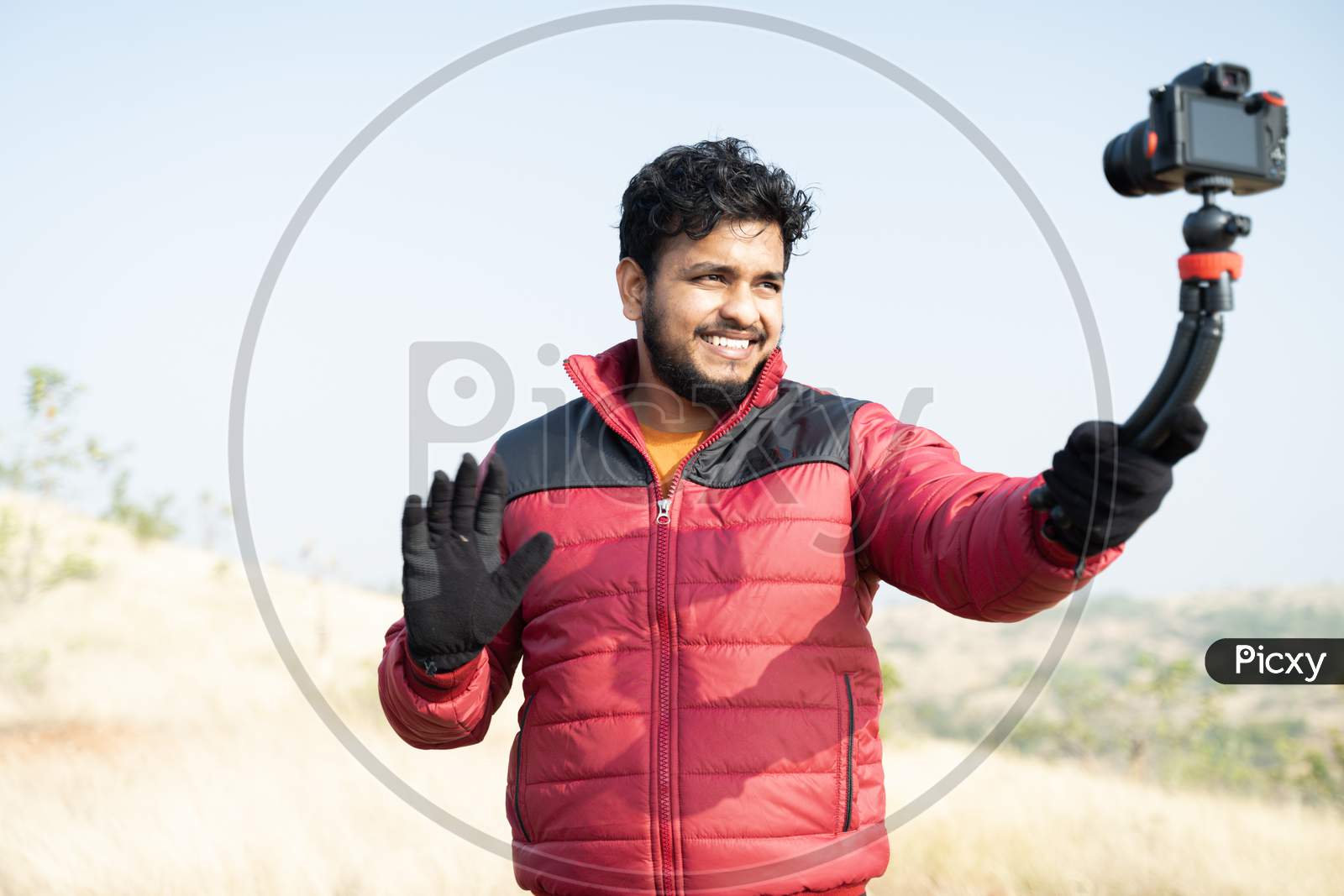 Young Traveller Busy Talking With Camera On Top Of Mountain - Concept Of Travel Vlogger, Blogger Or Influencer Recording Video During Hiking.