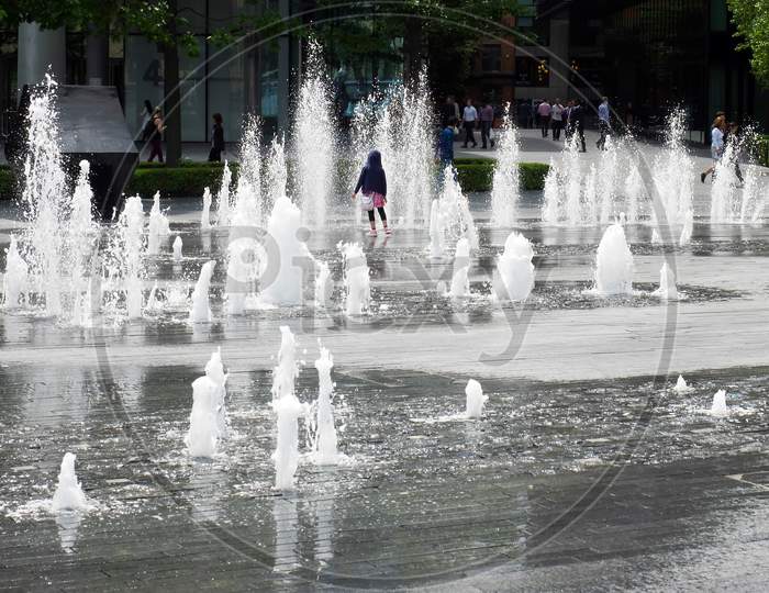 Person Standing In The Middle Of A Fountain In London