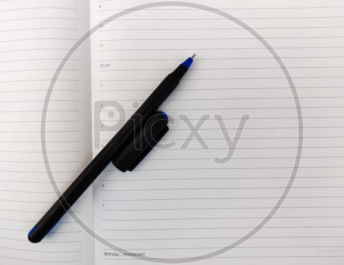 Top View Of Open Diary With Pen And Cap. Copy Space