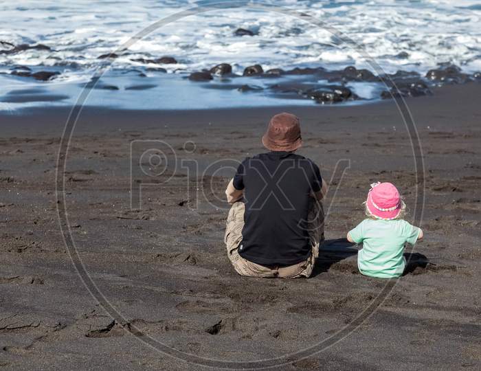 Dad And Daughter Watching The Waves