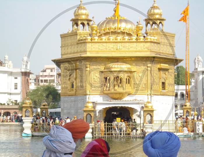 Sikh people looking at the Golden Temple