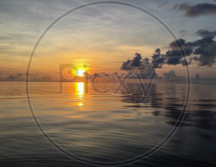 A Scenery Of Sunset Over The Water On The Sea