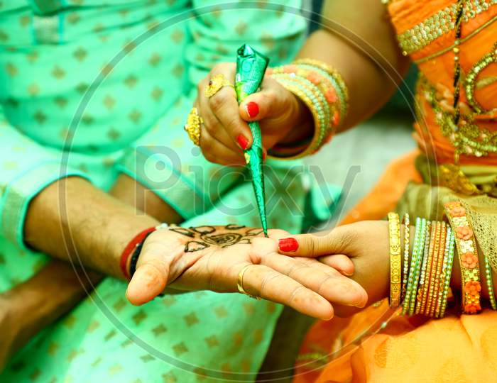 Indian Groom hands decoration with Heena Designs getting ready for marriage
