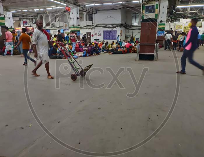 People wait in congestion to catch trains in hawrah railway station at night during pandemic situation.