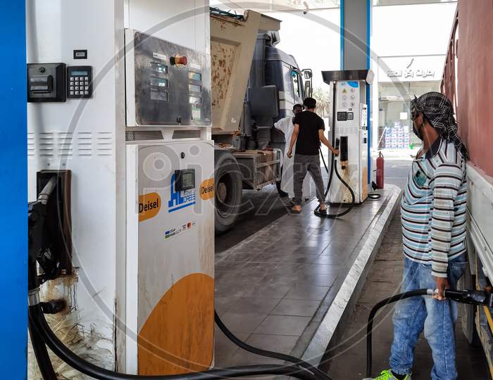 A man filling petrol at a petrol pump.