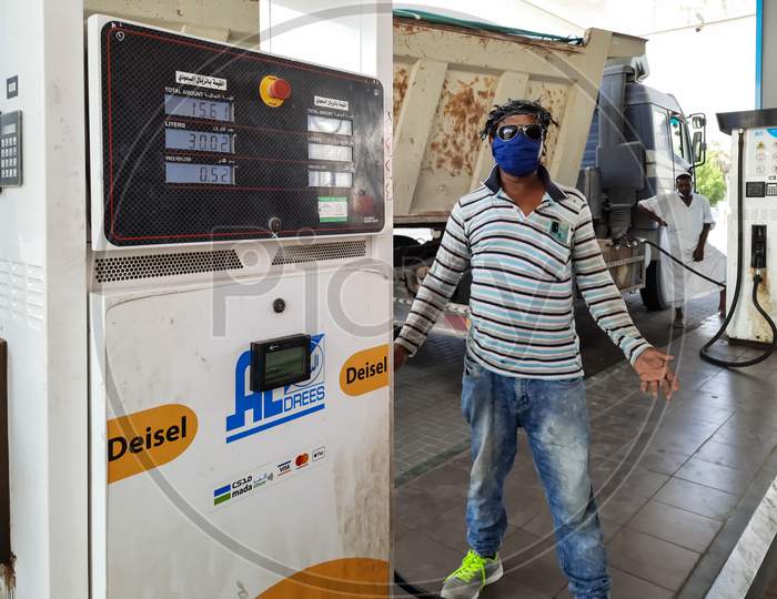 A man standing at a petrol pump.