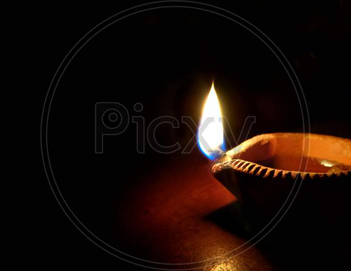 Close up shot of Diya or oil lamp on dark background on the occasion of Diwali festival of lights, India traditional fastival