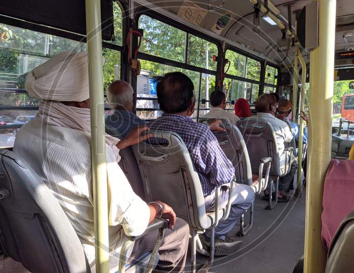 Passengers riding in a commuter bus (Press Photograph)