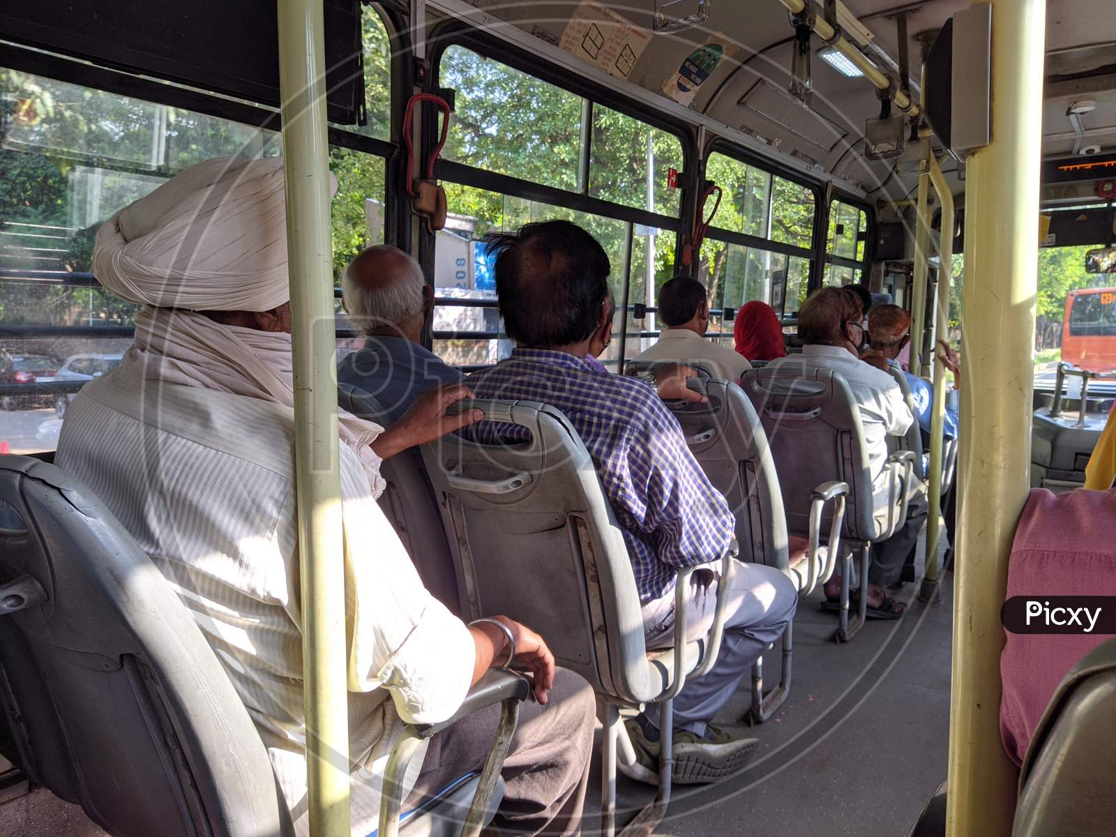 Passengers riding in a commuter bus (Press Photograph)