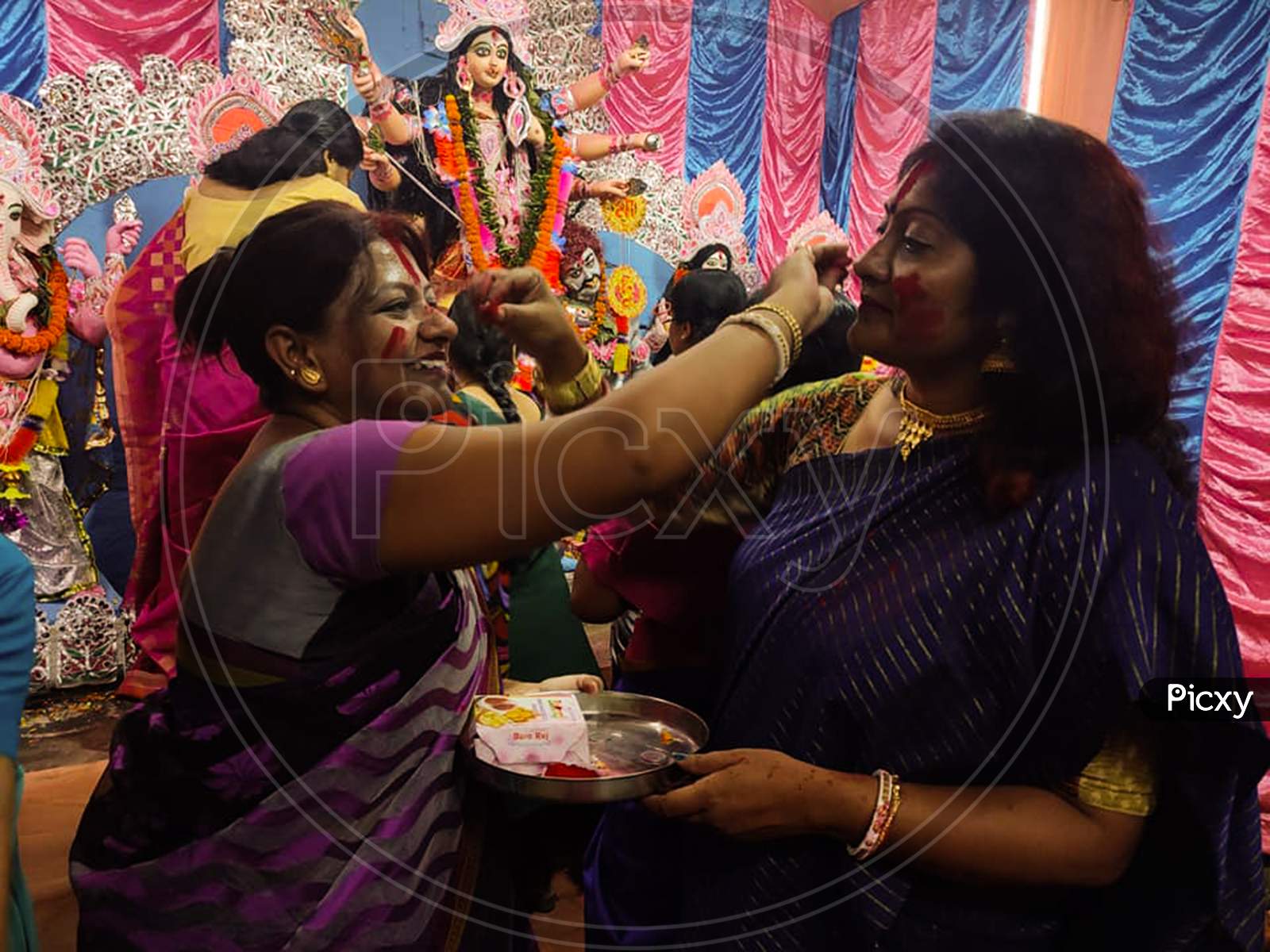Kolkata, West Bengal, India - 15 October 2021: Married Bengali Hindu Women Smear And Play With Vermilion During Sindur Khela Traditional Ceremony On The Final Day Of Durga Puja Festival.