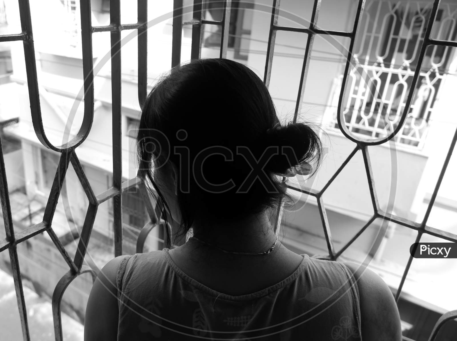 Isolated Black And White Image Of Girl Standing On Balcony And Watching Outside.