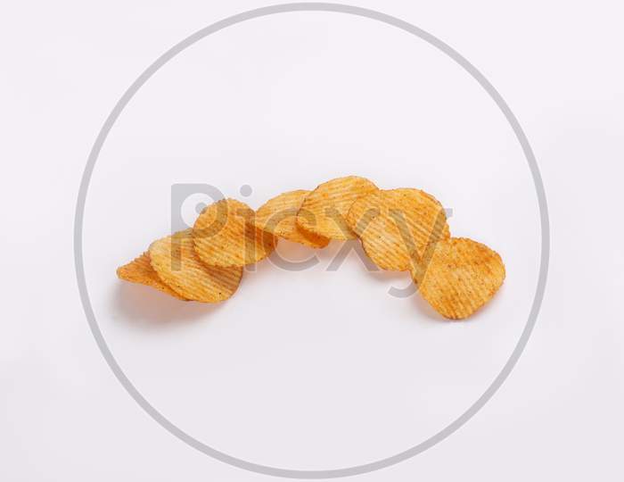 Bowl of tasty ridged potato chips on white background | top angle beautiful focused