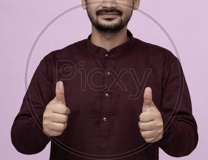 Young Indian Man Wearing Kurta Standing Over Isolated Background Doing Happy Thumbs Up Gesture With Hand. Approving Expression Looking At The Camera Showing Success.