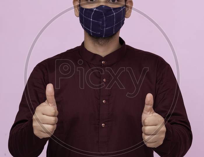 Indian Adult Boy Wearing Mask With Thumbs Up Gesture.