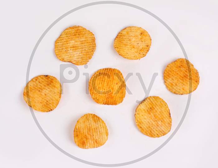 Bowl of tasty ridged potato chips on white background | top angle beautiful focused