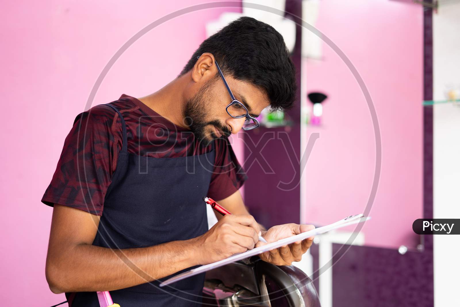 Barber Checking Financial Documents Or Agreement Papers Before Signing At Saloon.