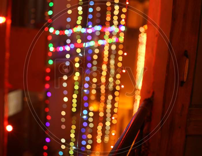 A balcony view of colourful diwali lights hanging from the roof.