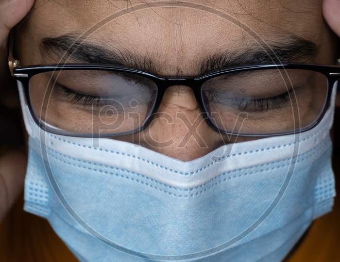 Boy With Spectacle Suffering From Headache Pain Due To Using Of Mask.