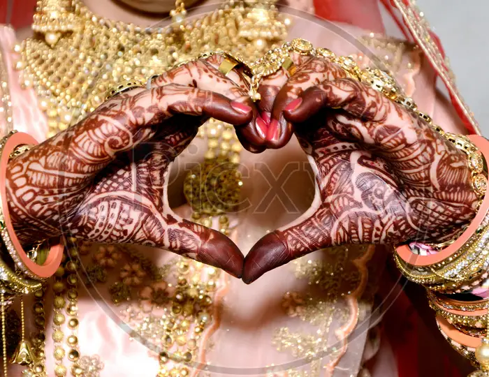 Pakistani & Indian bride wedding making a heart shape her hand