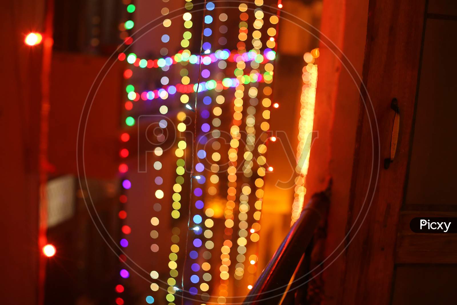 A balcony view of colourful diwali lights hanging from the roof.