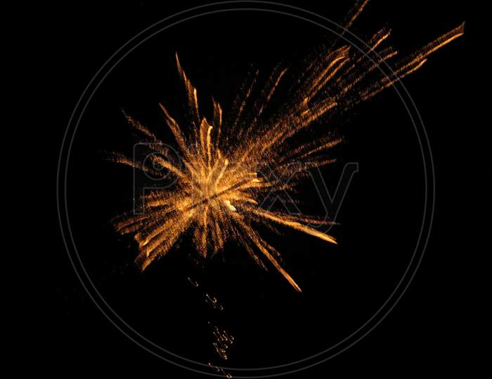 A cracker bursting up in the dark night sky. Diwali photography.