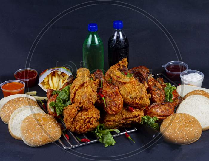Hot And Crispy Fried Chicken Legs And Grilled Chicken Legs Isolated On A Grill Platter.French Fries, Cold Drink And In Background