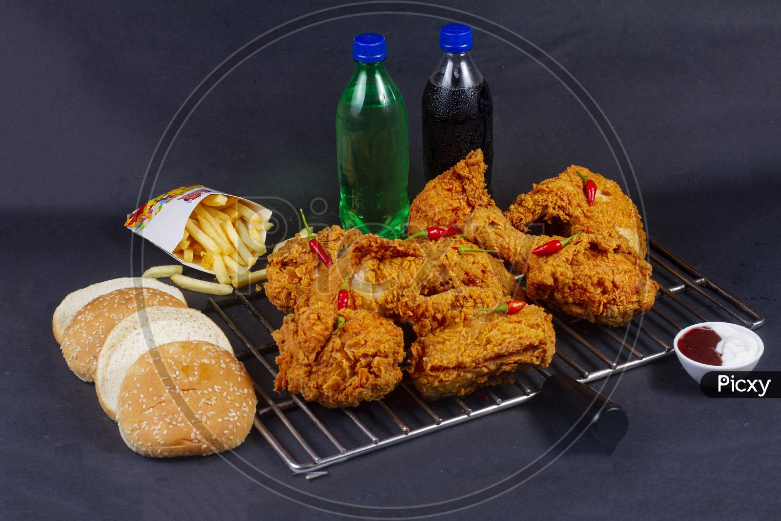 Hot And Crispy Fried Chicken Legs Isolated On A Grill Platter.French Fries, Cold Drink And In Background