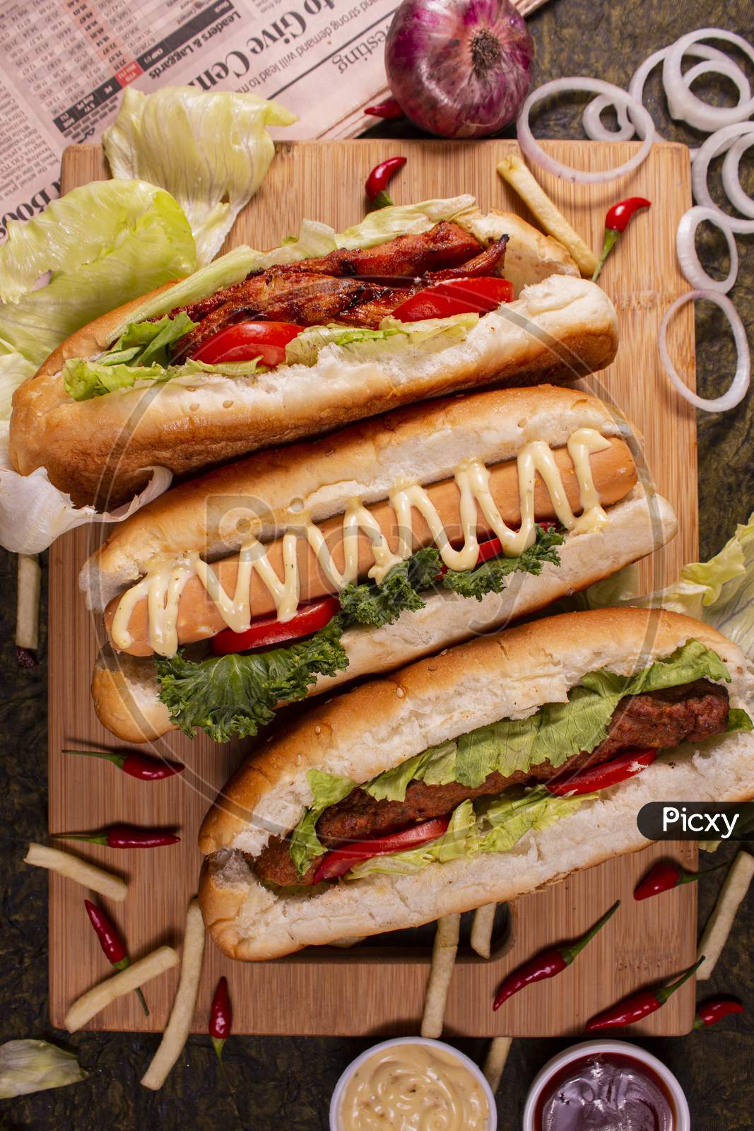 Different Variety Of Chicken Rolls Or Wrap On Wooden Plate And Black Background.Copy Scape.Top View.Different Variety Of Chicken Bun Rolls Or Wrap On Wooden Plate And Black Background.Copy Scape.Top View.
